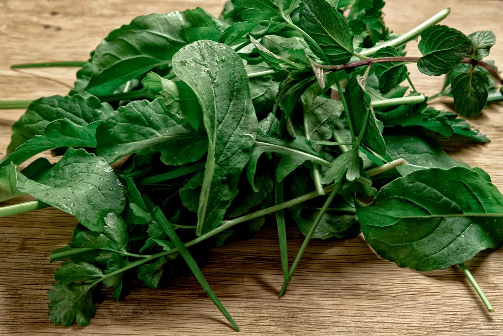 Fresh arugula rocket leaves piled on a wooden board