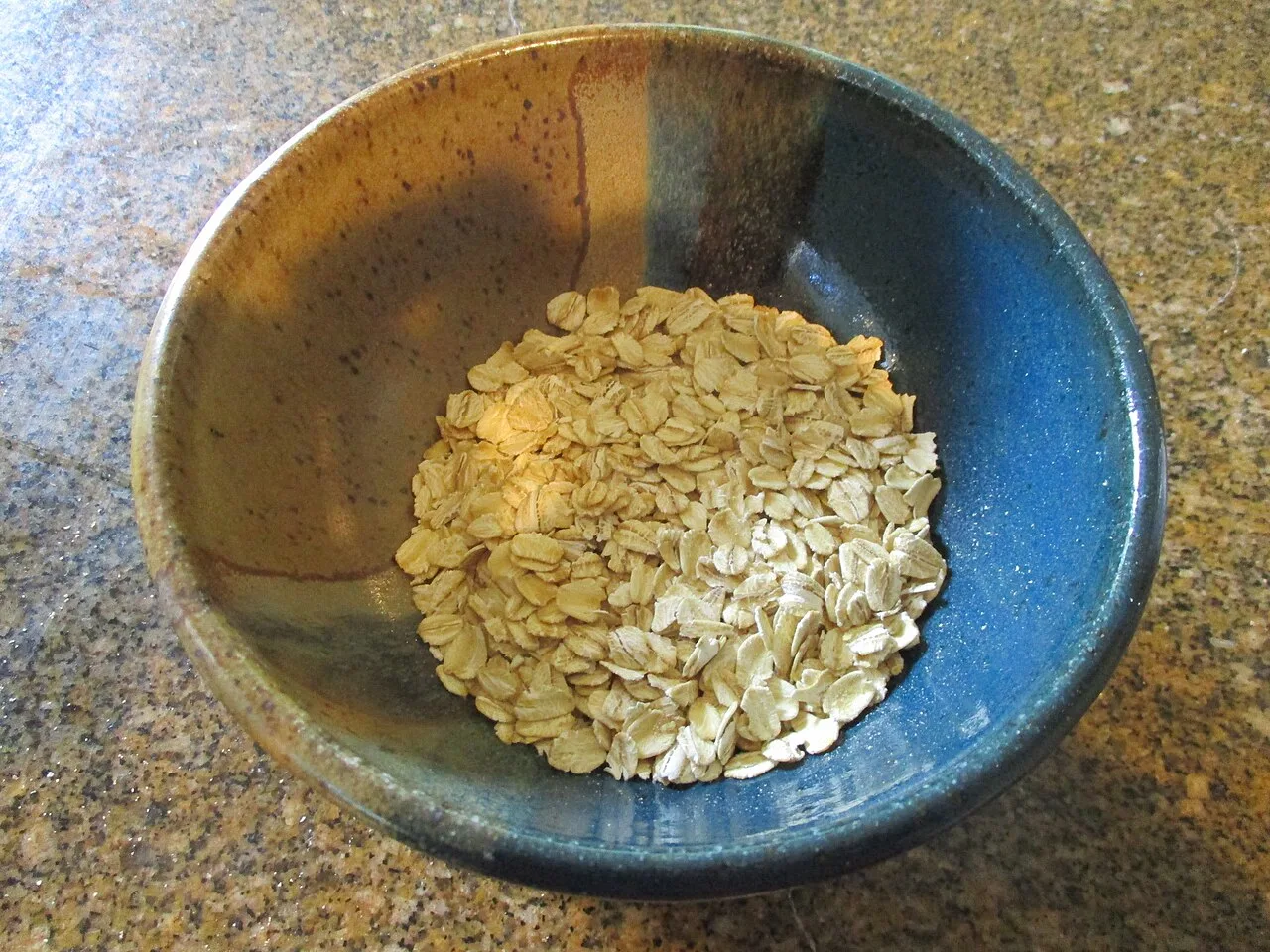 Dry rolled oats in a blue ceramic bowl