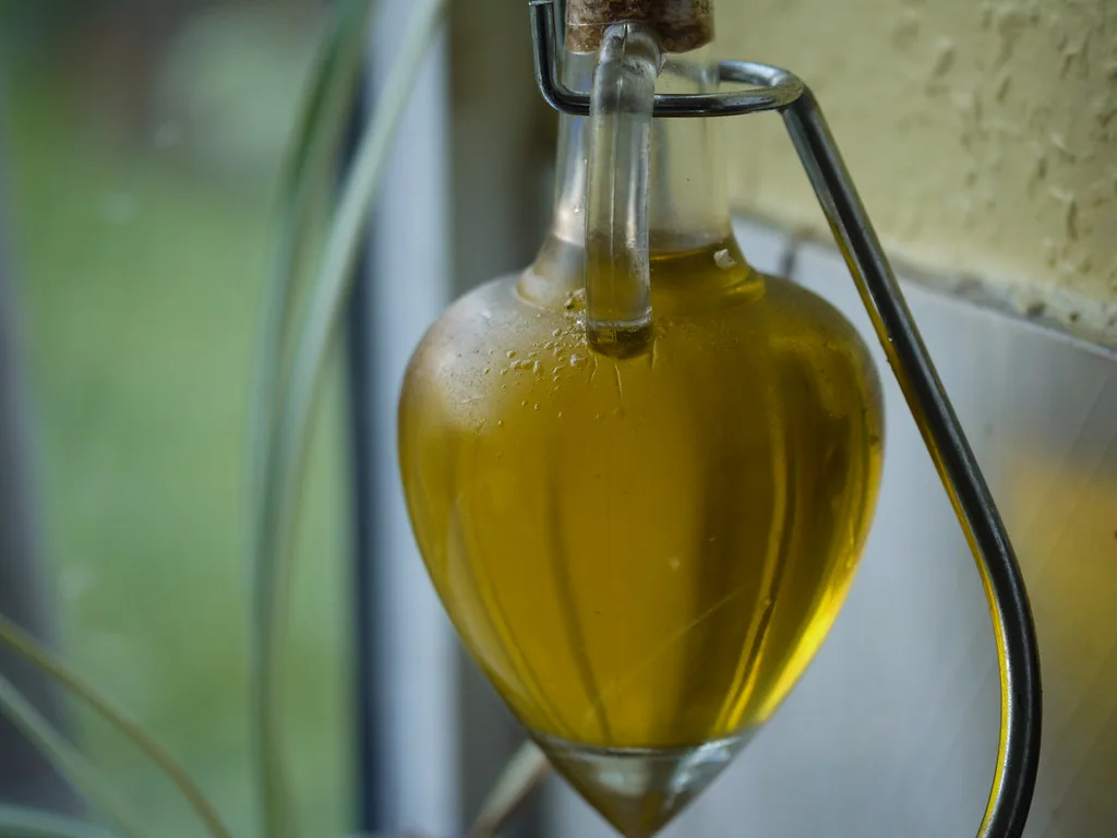 Green-gold olive oil in a clear glass jug