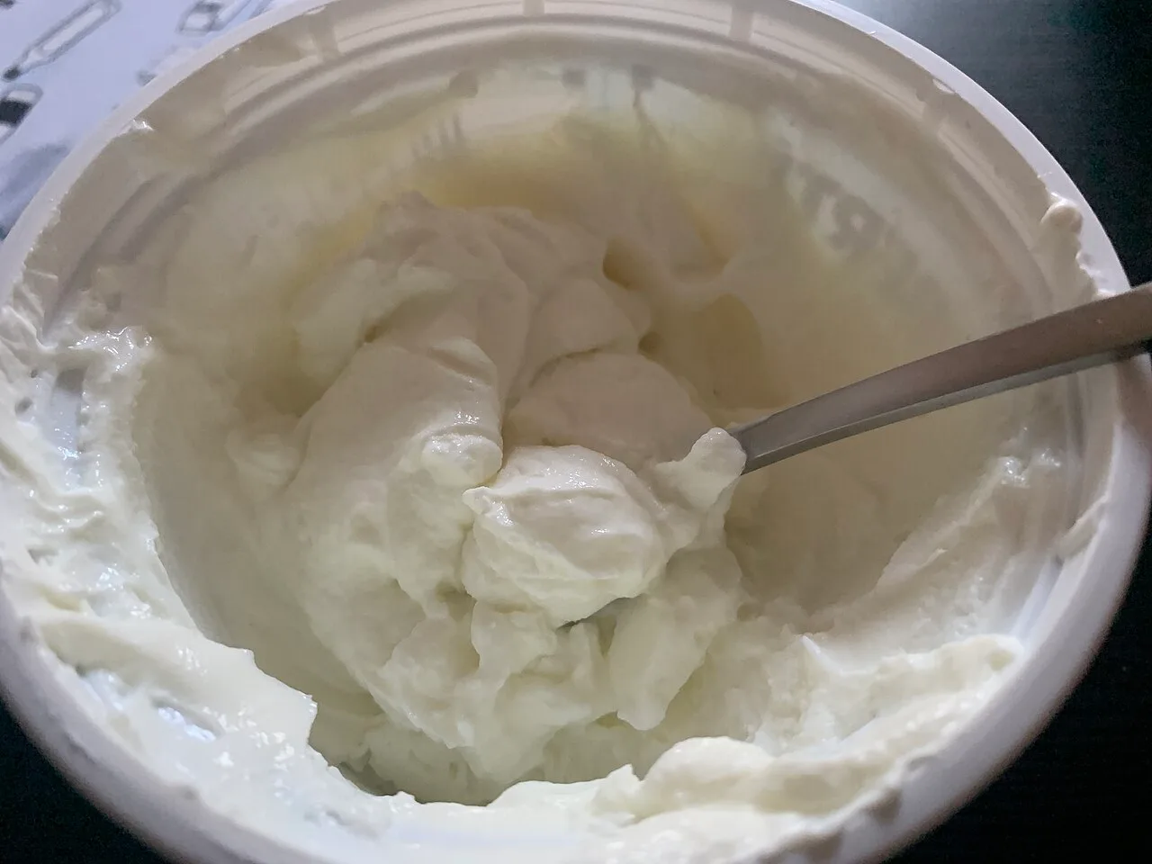 Thick white skyr in a container with a spoon